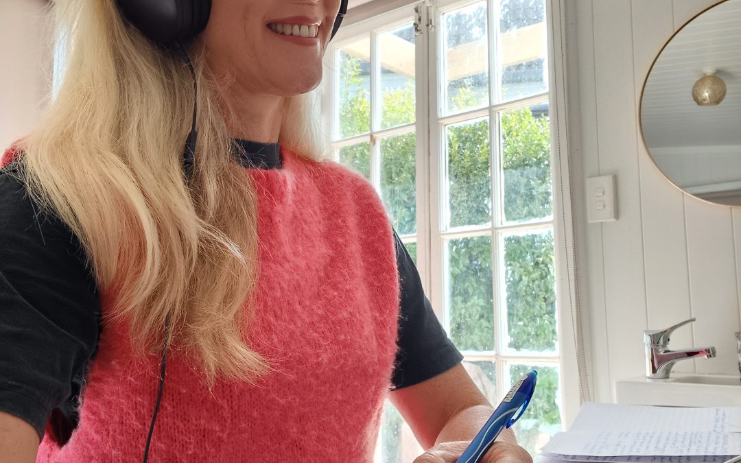 Jan on the phone with headphones on to a female client. She is a life coach.